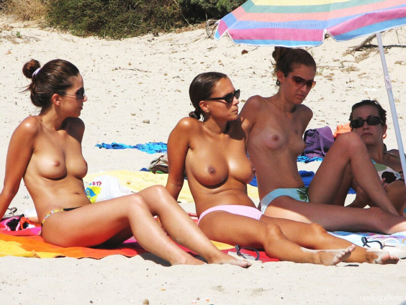 Three girls topless on the beach